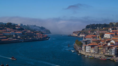 High angle view of town by sea against sky