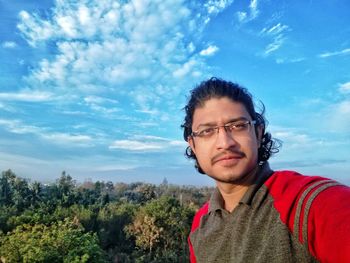 Portrait of young man against sky