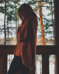 Midsection of woman standing by tree in winter