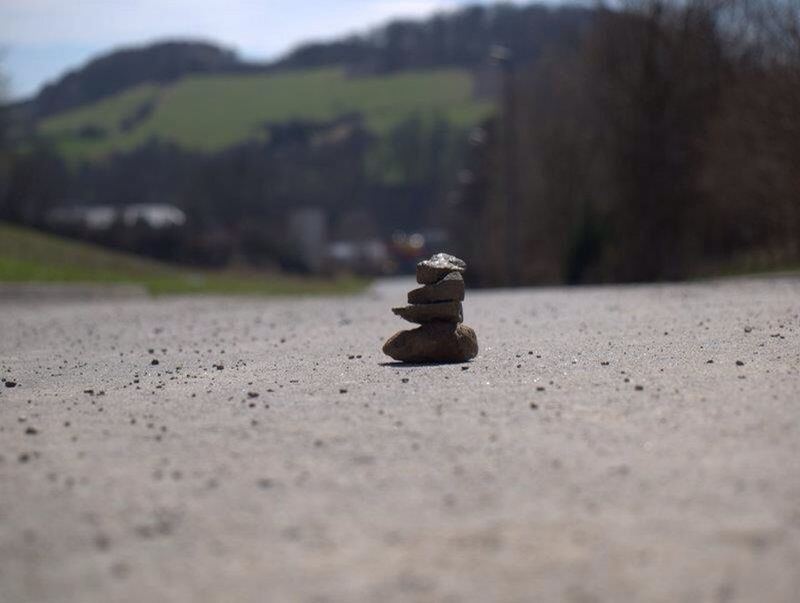 surface level, selective focus, focus on foreground, tranquility, nature, stone - object, close-up, rock - object, tranquil scene, sky, landscape, outdoors, day, sand, pebble, stone, textured, no people, beach, beauty in nature