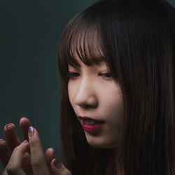 Close-up portrait of a beautiful young woman over black background