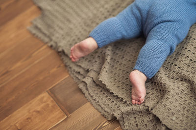 Low section of child sitting on wooden floor