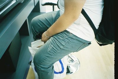 Midsection of person sitting on chair