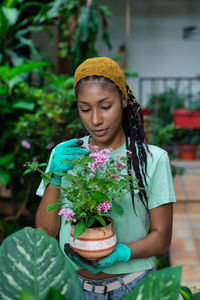 Girl looking away while standing on flower pot