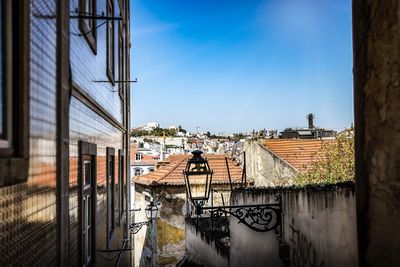 Canal by buildings against blue sky
