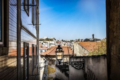 Canal by buildings against blue sky