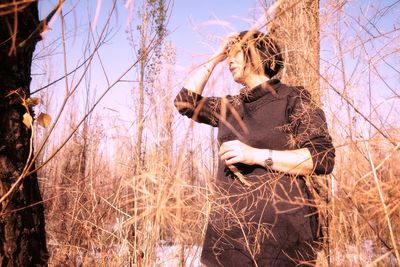 Woman sitting on field during winter