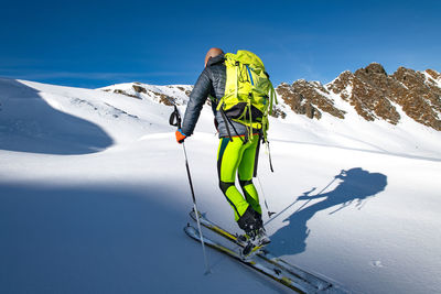 Person skiing on snowcapped mountain during winter
