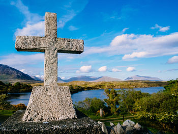 Close-up of cross against blue sky