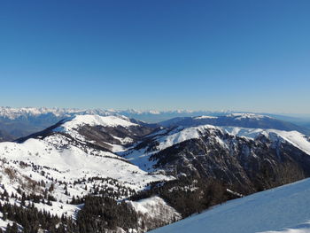 Scenic view of snowcapped mountains against clear blue sky