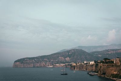 Sailboats in sea against sky