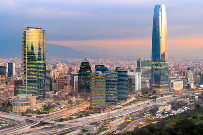 Aerial view of cityscape against cloudy sky