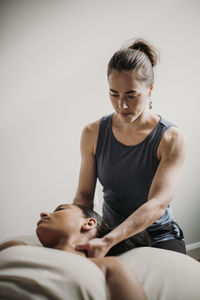 Female massage therapist treats her african american patient