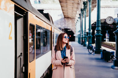 Woman standing on train in city
