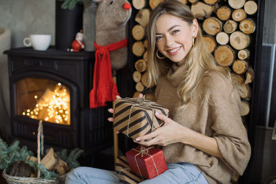 Portrait of smiling young woman holding camera