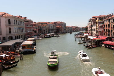 Boats in canal amidst buildings in city