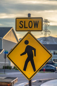 Information sign on road against sky in city