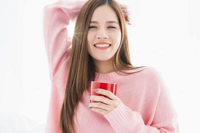 Portrait of smiling young woman holding coffee cup
