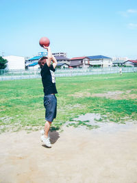 Full length of girl playing on grassy field