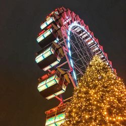 Low angle view of illuminated ferris wheel against sky at night