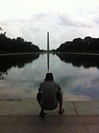 Rear view of man in lake against sky