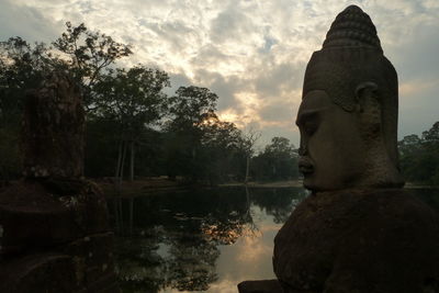 Statue by trees against sky