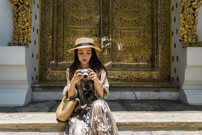 Young woman photographing with mobile phone