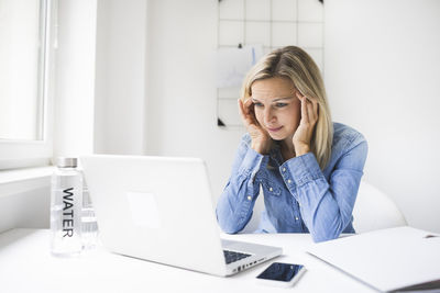 Frustrated businesswoman staring laptop while working at home