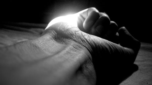 Close-up of human hand against black background