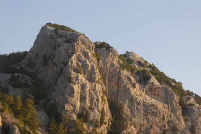 Low angle view of rocks against clear sky