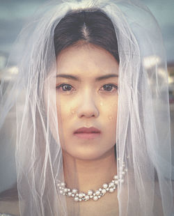 Portrait of crying bride standing at wedding ceremony