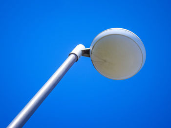 Low angle view of street light against blue sky