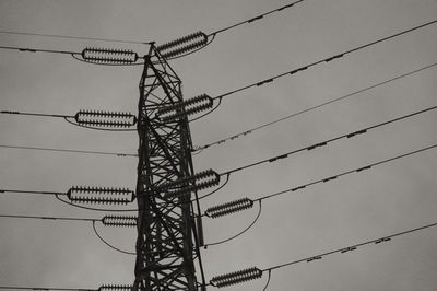 Low angle view of electricity pylon against clear sky