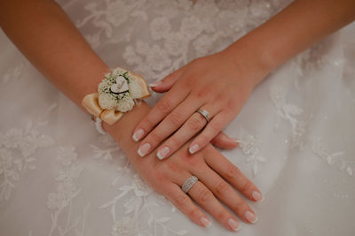 Cropped hands of woman holding wedding dress