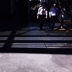 People walking on sidewalk in city at night