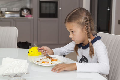 Girl sitting on table at home