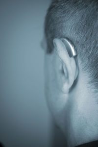 Close-up of man wearing mask against gray background