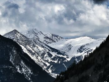 Scenic view of snowcapped mountains against cloudy sky