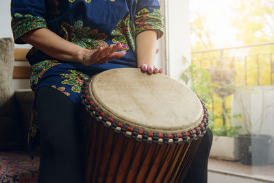 Midsection of woman playing drum