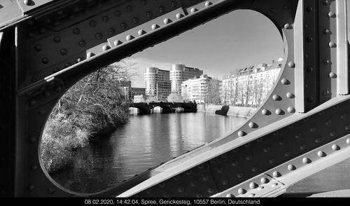 Bridge over river amidst buildings in city