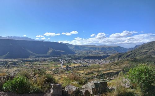 Scenic view of landscape and mountains against blue sky