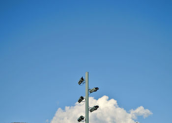 Low angle view of street light against blue sky