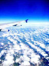 Airplane flying over sea against blue sky