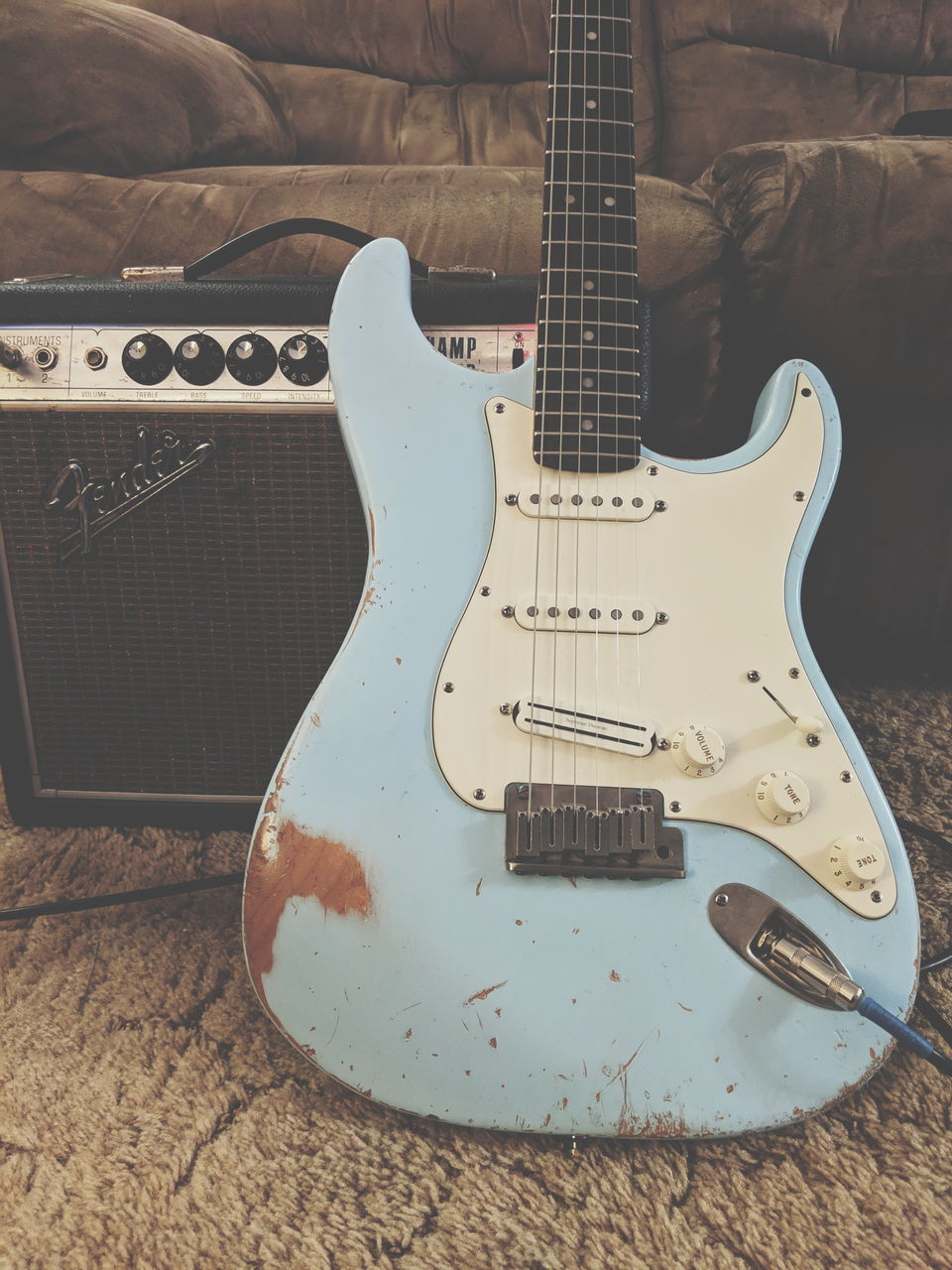 HIGH ANGLE VIEW OF GUITAR ON PIANO