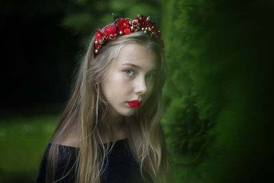 Portrait of girl wearing red lipstick against plants