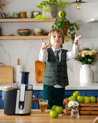 Cute schoolboy makes fresh apple juice for breakfast. vitamins and healthy nutrition for schoolers