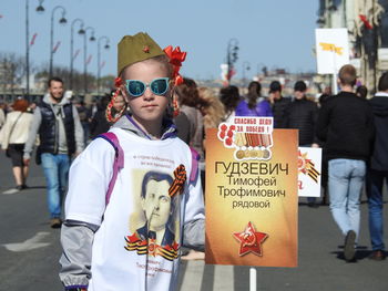 Portrait of girl holding placard on street