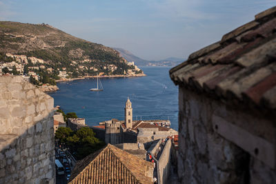 High angle view of townscape by sea against sky