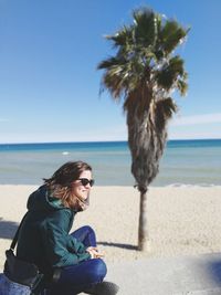 Full length of woman sitting on beach