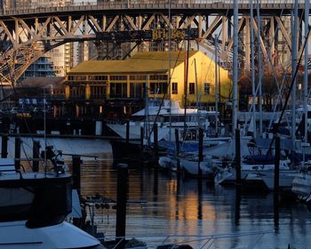 Sailboats moored on harbor in city